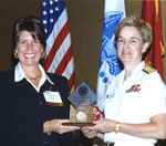 Rear Admiral Bird, Commander DSCC, presents DARE with DSCC’s Gold Medal Excellence Award